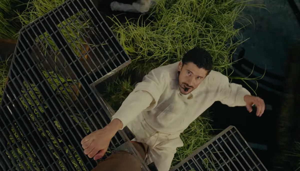 Bad Bunnty is a latino man in a white workout suit, climbing a prop powerline during the Super Bowl Half-Time Show.